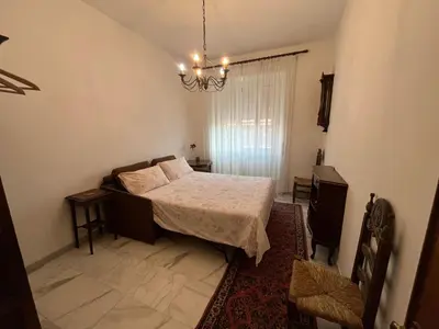 a bedroom with a bed and a chandelier at corte degli ulivi in roma in Rome
