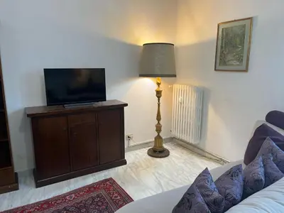 a living room with a flat screen tv and a lamp at corte degli ulivi in roma in Rome