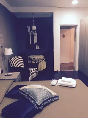 a blue room with a bed and a chair at B&B Le Vibrazioni in Rome