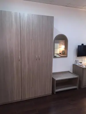 a room with wooden cabinets with a bench and a mirror at B&B Le Vibrazioni in Rome