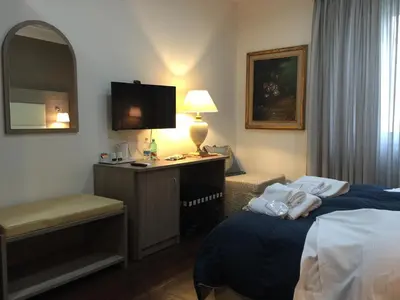 a hotel room with two beds and a desk at B&B Le Vibrazioni in Rome