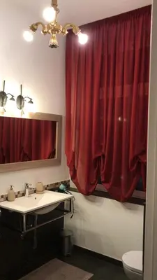 a bathroom with a sink and a red curtain at B&B Le Vibrazioni in Rome