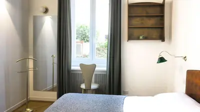 a bedroom with a chair next to a window at Roman Forum Rooms in Rome