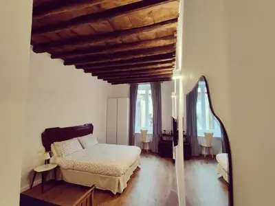 a bedroom with a bed and a wooden ceiling at Roman Forum Rooms in Rome