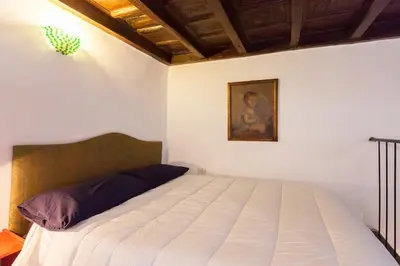 a bedroom with a bed with a painting on the wall at Apartment in Rome-Trastevere - Amorhome in Rome