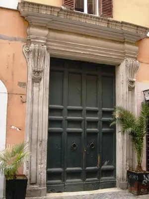 a large green door on a building with plants at Apartment in Rome-Trastevere - Amorhome in Rome