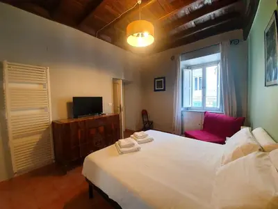 a bedroom with a large white bed and a tv at Laterano Home in Rome
