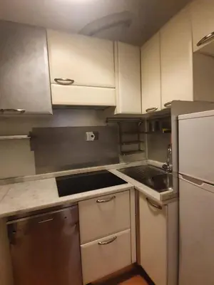 a kitchen with white cabinets and stainless steel appliances at Laterano Home in Rome