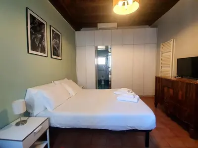 a bedroom with two beds and a television in it at Laterano Home in Rome