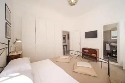 a white bedroom with a bed and a tv at Vatican Domus by BuddyRent in Rome