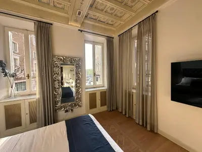 a bedroom with a bed and a mirror and windows at Residenza Nobile Vittoria in Rome