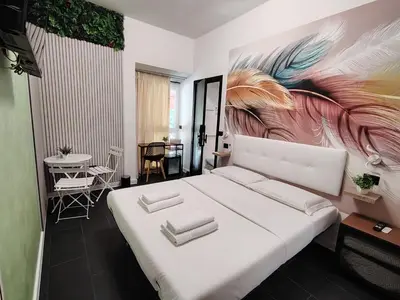 a bedroom with a large white bed with a painting on the wall at Le Regine - Home suites - Adult Only in Rome