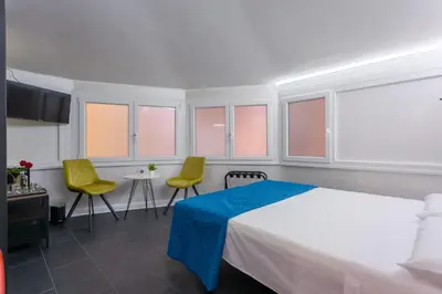 a bedroom with a bed and two chairs and a table at Le Regine - Home suites - Adult Only in Rome