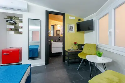 a room with a bed and a desk and a table at Le Regine - Home suites - Adult Only in Rome