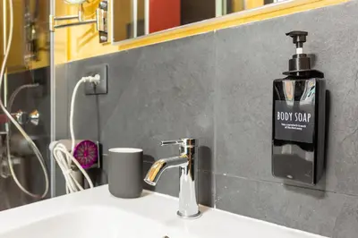 a soap dispenser on a sink in a bathroom at Le Regine - Home suites - Adult Only in Rome