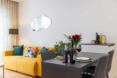 a living room with a yellow couch and a table at Suite & Outdoor Patio - Colosseum & Fori Imperiali in Rome