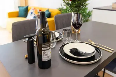 a bottle of wine and plates on a table at Suite & Outdoor Patio - Colosseum & Fori Imperiali in Rome