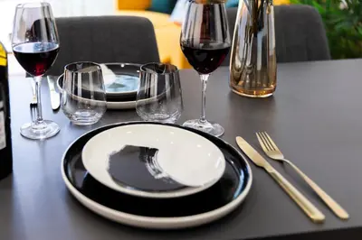 a table with two plates and glasses of wine at Suite & Outdoor Patio - Colosseum & Fori Imperiali in Rome