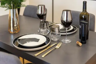 a table with two plates and glasses of wine at Suite & Outdoor Patio - Colosseum & Fori Imperiali in Rome