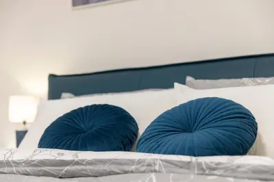 two blue pillows sitting on top of a bed at Suite & Outdoor Patio - Colosseum & Fori Imperiali in Rome