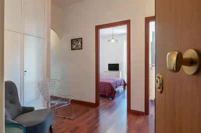 a living room with a chair and a bedroom at GuestHost - Close to St Peter in Rome