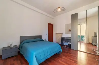 a bedroom with a blue bed and a desk at GuestHost - Close to St Peter in Rome
