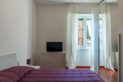 a bedroom with a purple bed and a television at GuestHost - Close to St Peter in Rome