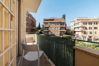 a white chair sitting on a balcony with buildings at GuestHost - Close to St Peter in Rome