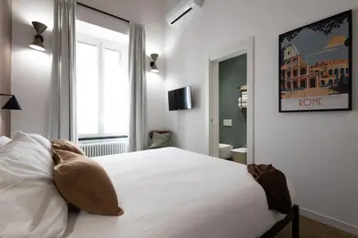 a bedroom with a white bed and a window at Style & Stone Guest House in Rome