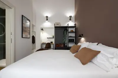 a bedroom with a large white bed with two pillows at Style & Stone Guest House in Rome