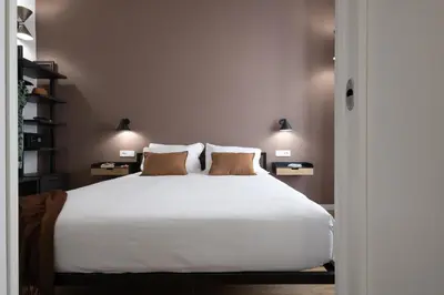 a bedroom with a large white bed with two pillows at Style & Stone Guest House in Rome