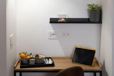 a desk with a laptop and a tray of fruit at Style & Stone Guest House in Rome