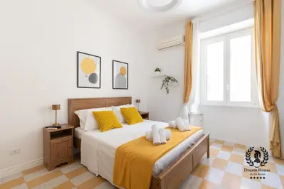 a bedroom with a large bed with yellow pillows at Dream House Re di Roma - 50mt to Metro Station, central position, 4pax, 2bdr in Rome