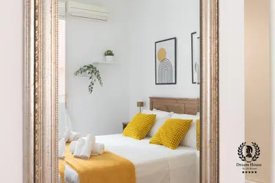 a mirror in a bedroom with a bed with yellow pillows at Dream House Re di Roma - 50mt to Metro Station, central position, 4pax, 2bdr in Rome