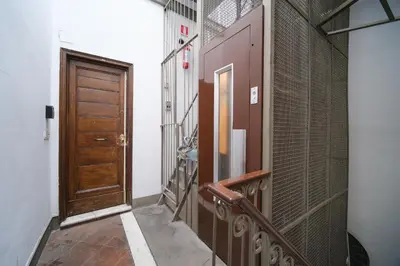 a hallway with a wooden door and a staircase at Monti's View by BuddyRent in Rome