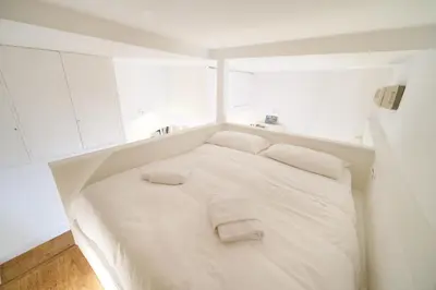 a white bed in a room with white cabinets at Monti's View by BuddyRent in Rome