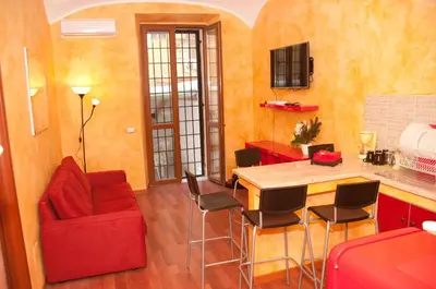 a living room with a red couch and a table at Lucky Domus Esquilino in Rome