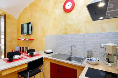 a kitchen with a sink and a red clock on the wall at Lucky Domus Esquilino in Rome