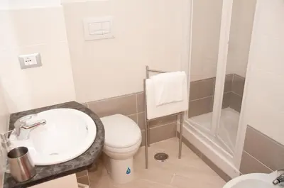 a bathroom with a toilet and a sink and a shower at Lucky Domus Esquilino in Rome