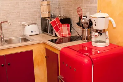 a kitchen with a red refrigerator next to a sink at Lucky Domus Esquilino in Rome