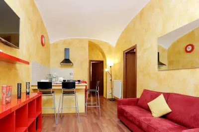a living room with a red couch and a kitchen at Lucky Domus Esquilino in Rome