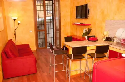a kitchen with a red couch and a table and chairs at Lucky Domus Esquilino in Rome