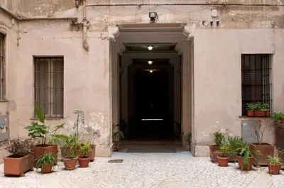 a black door in a building with potted plants at Lucky Domus Esquilino in Rome