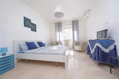 a white and blue bedroom with a bed and a couch at Vatican Francy's House - San Pietro Rome in Rome