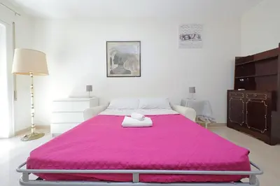 a large bed with a pink blanket on top of it at Vatican Francy's House - San Pietro Rome in Rome