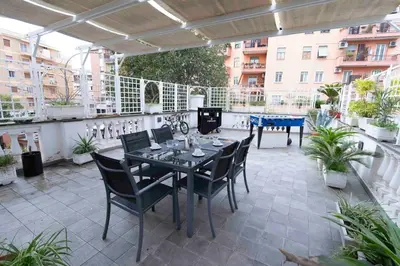a patio with a table and chairs on a balcony at Hermès Apartment Rome in Rome