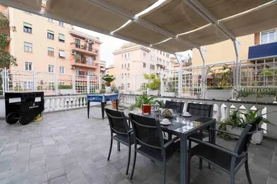 a patio with tables and chairs on a balcony at Hermès Apartment Rome in Rome