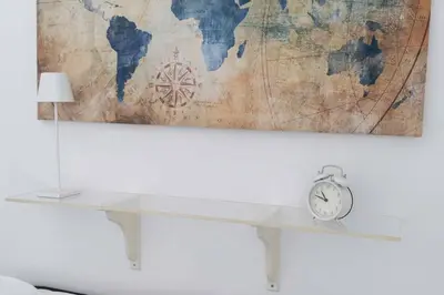 a clock sitting on a shelf next to a world map at Hermès Apartment Rome in Rome