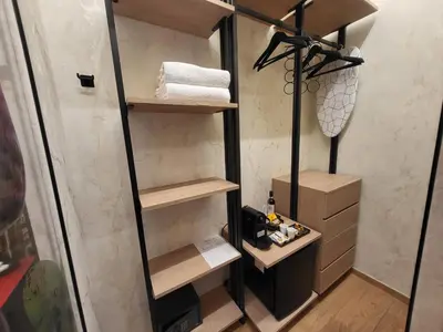 a walk in shower with wooden shelves and towels at Venus Inn Vatican Guest House in Rome