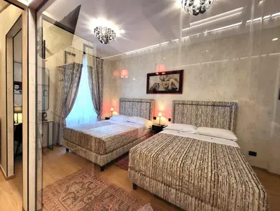 a bedroom with two beds and a mirror at Venus Inn Vatican Guest House in Rome
